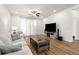 Cozy living room with hardwood floors, a ceiling fan, and a modern entertainment center at 4718 Arbor Gate Dr, Bradenton, FL 34203