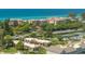 Stunning aerial view of the property surrounded by lush greenery, nearby beach and residential buildings at 4840 Gulf Of Mexico Dr # Villa 15, Longboat Key, FL 34228