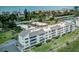 This aerial view shows the property is surrounded by beaches, water, and lush greenery at 4840 Gulf Of Mexico Dr # Villa 15, Longboat Key, FL 34228