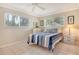 Bright bedroom with two windows, neutral walls, tile floors, and nautical-themed bedding at 4840 Gulf Of Mexico Dr # Villa 15, Longboat Key, FL 34228