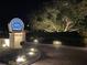 Well-lit entrance to a community with lush landscaping and clear signage, creating a welcoming ambiance at night at 4840 Gulf Of Mexico Dr # Villa 15, Longboat Key, FL 34228