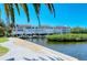 Multi-story waterfront building featuring private boat docks and lush greenery at 4840 Gulf Of Mexico Dr # Villa 15, Longboat Key, FL 34228