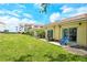 Beautiful backyard with lawn, mature trees, patio, and blue lounge chairs at 4840 Gulf Of Mexico Dr # Villa 15, Longboat Key, FL 34228