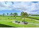 Scenic view of lush green space with palm trees, manicured lawns, and the tranquil river in the background at 4840 Gulf Of Mexico Dr # Villa 15, Longboat Key, FL 34228