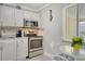 Practical kitchen featuring stainless steel appliances, white cabinets, and a cozy dining area at 4840 Gulf Of Mexico Dr # Villa 15, Longboat Key, FL 34228