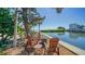 Relaxing outdoor seating area with comfortable chairs around a fire pit, overlooking the tranquil waterfront at 4840 Gulf Of Mexico Dr # Villa 15, Longboat Key, FL 34228