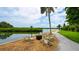 Inviting outdoor seating area with comfortable chairs around a fire pit, overlooking the tranquil waterfront at 4840 Gulf Of Mexico Dr # Villa 15, Longboat Key, FL 34228