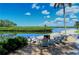 Inviting outdoor seating area with comfortable chairs around a fire pit, overlooking the tranquil waterfront at 4840 Gulf Of Mexico Dr # Villa 15, Longboat Key, FL 34228
