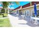Enjoy this patio with outside seating, tables, blue umbrellas, and a pleasant exterior view at 4840 Gulf Of Mexico Dr # Villa 15, Longboat Key, FL 34228