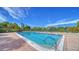 A refreshing swimming pool with clear blue water, surrounded by a brick patio and lush tropical landscaping at 4840 Gulf Of Mexico Dr # Villa 15, Longboat Key, FL 34228