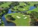 Scenic aerial view of a golf course featuring lush green fairways, water features, and mature trees at 4920 Woodhurst Dr, Sarasota, FL 34243