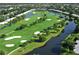 Aerial view of community golf course highlighting green fairways, sand traps, water features, and residential area at 4920 Woodhurst Dr, Sarasota, FL 34243