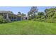 Lush green backyard featuring screened lanai, water feature, and peaceful landscaping at 4920 Woodhurst Dr, Sarasota, FL 34243