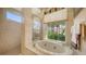 Bright bathroom featuring separate glass shower, garden tub, and large window with privacy at 4920 Woodhurst Dr, Sarasota, FL 34243