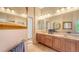 Bathroom showcasing double sinks, a large mirror, and neutral tile flooring at 4920 Woodhurst Dr, Sarasota, FL 34243