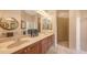 Bathroom featuring double sinks with tan countertops and tiled walk-in shower at 4920 Woodhurst Dr, Sarasota, FL 34243