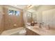 Bright bathroom with a bathtub, shower, natural light and a neutral color scheme at 4920 Woodhurst Dr, Sarasota, FL 34243