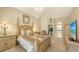 Brightly lit bedroom boasts a four-poster bed, neutral color palette, and access to an en-suite bath at 4920 Woodhurst Dr, Sarasota, FL 34243