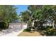 Charming single-story home with a two-car garage, mature trees, and a well-manicured lawn at 4920 Woodhurst Dr, Sarasota, FL 34243