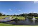 Charming golf course scene with a wooden bridge, fountain pond, and green fairways at 4920 Woodhurst Dr, Sarasota, FL 34243