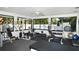 Bright community gym with modern weight machines, dumbbells, ceiling fan, and large windows overlooking the pool at 4920 Woodhurst Dr, Sarasota, FL 34243