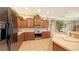 Well-lit kitchen features custom wood cabinetry, stainless steel appliances, and stone countertops at 4920 Woodhurst Dr, Sarasota, FL 34243