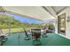 Relaxing screened-in lanai with green turf, patio furniture and a scenic view at 4920 Woodhurst Dr, Sarasota, FL 34243