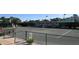 Well-maintained tennis court at the Palm-Aire Racquet Club, surrounded by lush greenery and fencing at 4920 Woodhurst Dr, Sarasota, FL 34243