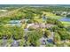 An aerial view highlighting the golf course, tennis courts, pool, and lush trees at 5035 Tobermory Way, Bradenton, FL 34211