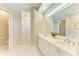 Luxurious bathroom featuring double sinks, a large mirror, and a walk-in shower with marble tiling at 5035 Tobermory Way, Bradenton, FL 34211