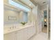 Elegant bathroom featuring double sinks, a large mirror, and natural lighting from a window at 5035 Tobermory Way, Bradenton, FL 34211