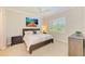 Cozy bedroom featuring a ceiling fan, a large window with shutters, and neutral decor at 5035 Tobermory Way, Bradenton, FL 34211
