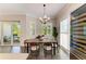Inviting dining room with patio access, wood table, and a contemporary wine fridge at 5035 Tobermory Way, Bradenton, FL 34211