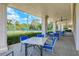 Covered patio with tables and chairs offers a relaxing spot to view the tennis courts at 5035 Tobermory Way, Bradenton, FL 34211