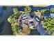 Waterfront home with lush landscaping, boat dock, private pool, and tile roof at 5500 Merrimac Dr, Sarasota, FL 34231