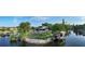 Panoramic view of a backyard with a boat dock, canal access, and mature landscaping enhance this property at 5500 Merrimac Dr, Sarasota, FL 34231
