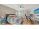 Neutral bedroom featuring hardwood floors, a ceiling fan, and ample natural light at 5500 Merrimac Dr, Sarasota, FL 34231
