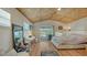 Bedroom with woven ceiling, sliding glass door to balcony, and desk setup at 5500 Merrimac Dr, Sarasota, FL 34231