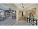 Indoor/outdoor living with bar seating, and open access to a screened lanai and outdoor bar at 5500 Merrimac Dr, Sarasota, FL 34231