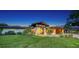 Home's exterior elevation with lush landscaping and an expansive front lawn at 5500 Merrimac Dr, Sarasota, FL 34231