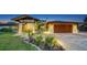 Exterior elevation of the home with meticulous landscaping, outdoor lighting, and brick driveway at 5500 Merrimac Dr, Sarasota, FL 34231