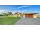 A beautifully landscaped home featuring a paver driveway and lush green lawn at 5500 Merrimac Dr, Sarasota, FL 34231