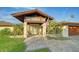 Inviting front entrance with stone columns, a covered walkway, and manicured landscaping at 5500 Merrimac Dr, Sarasota, FL 34231
