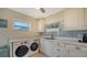 Convenient laundry room with washer, dryer, and plenty of cabinet storage at 5500 Merrimac Dr, Sarasota, FL 34231