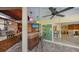 Covered outdoor kitchen featuring a bar, grill, television, and pass through to indoor living area at 5500 Merrimac Dr, Sarasota, FL 34231