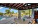 Covered patio with dining set, lounge furniture, pool, and scenic canal view at 5500 Merrimac Dr, Sarasota, FL 34231
