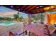 An inviting outdoor patio area with seating, a wood ceiling, and views of the pool at 5500 Merrimac Dr, Sarasota, FL 34231