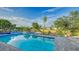 Sparkling pool and spa with blue tile accents, lush landscaping, and waterfront views at 5500 Merrimac Dr, Sarasota, FL 34231