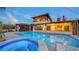 An inviting pool and jacuzzi with serene landscaping, a private cabana, and home at 5500 Merrimac Dr, Sarasota, FL 34231