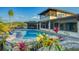Inviting outdoor pool area with lush landscaping and ample seating for ultimate relaxation and enjoyment at 5500 Merrimac Dr, Sarasota, FL 34231